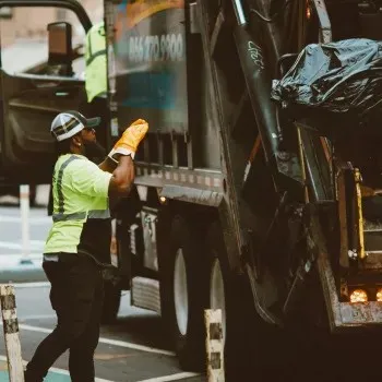 Sanitation worker standing by truck