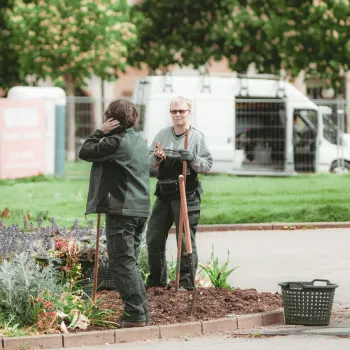 Two park workers holding shovels