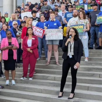 A woman holding a microphone in front of a pro-union crowd on the Colorado state capitol steps